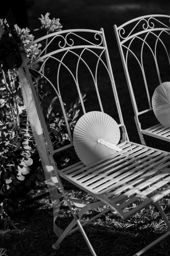 Primo piano in bianco e nero di sedia in ferro battuto con ventaglio cerimonia